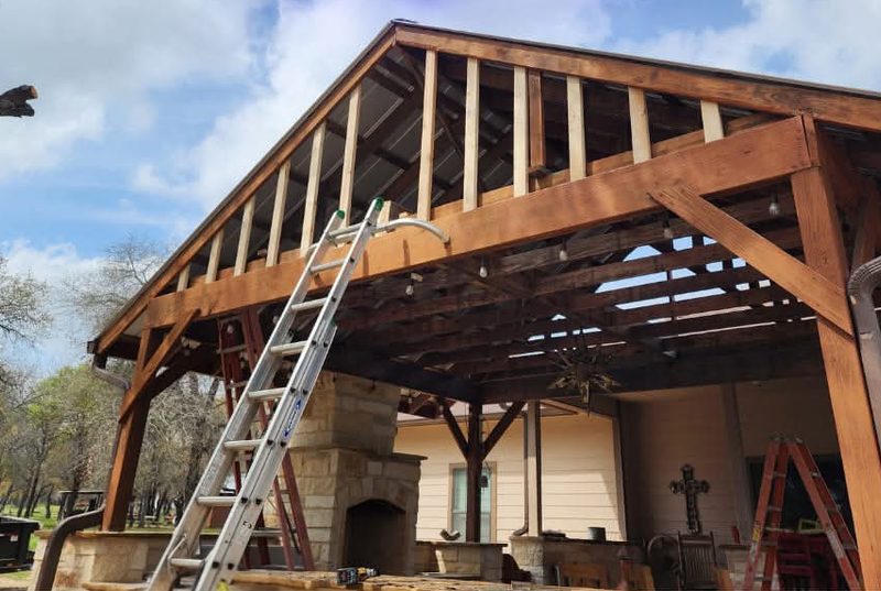Pérgola de madera con el triángulo superior abierto y una escalera apoyada